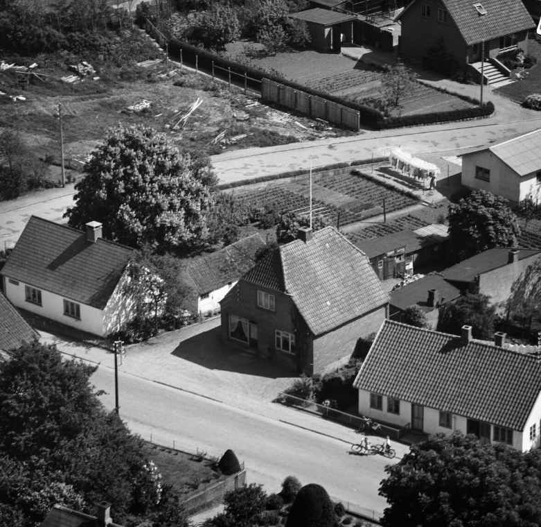 På Ørslevvej 112 var der indtil 1958 slagterbutik. Dette luftfoto er fra 1959, kort tid efter butikken er lukket.  Sylvest Jensen luftfoto, 1959. Det Kongelige Bibliotek.